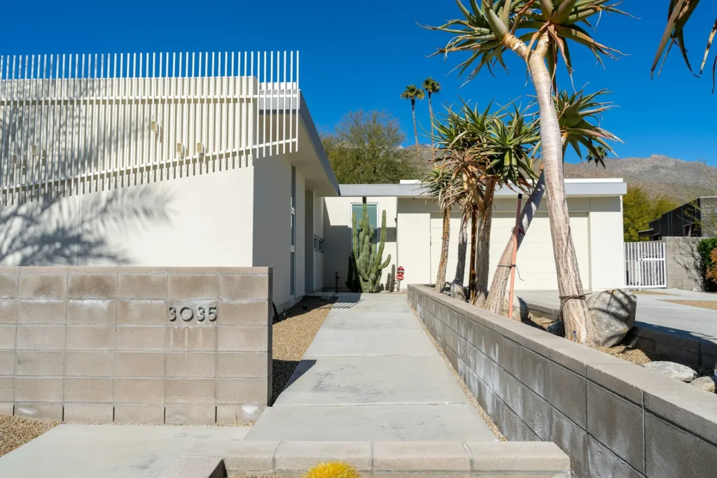 Modern white building with palm trees.