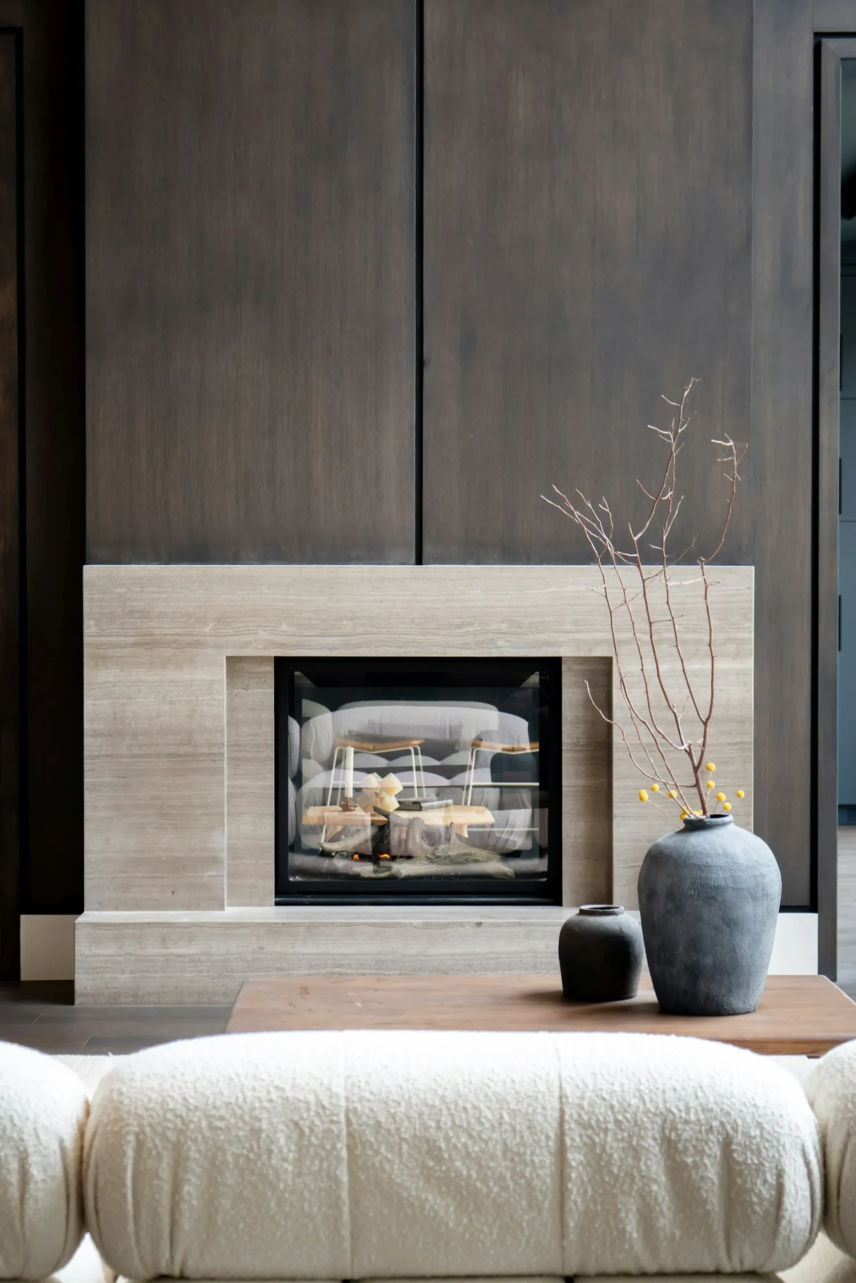 Modern fireplace with dark wall and wood floor.