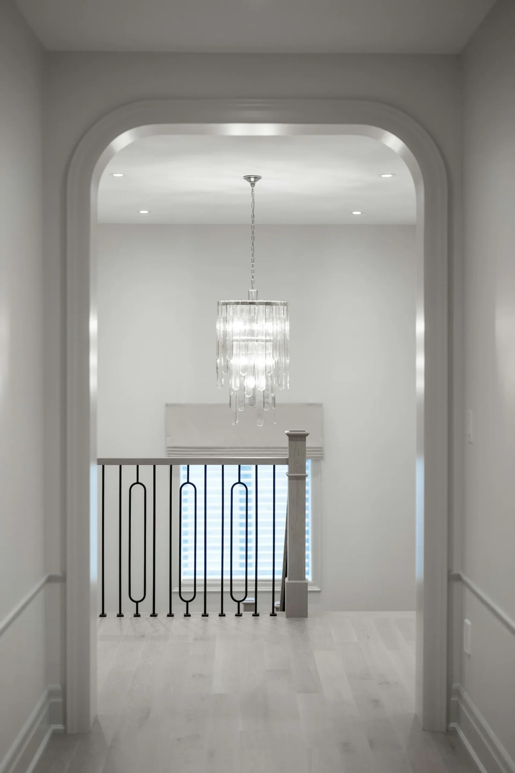 Bright hallway with white walls and hanging light.