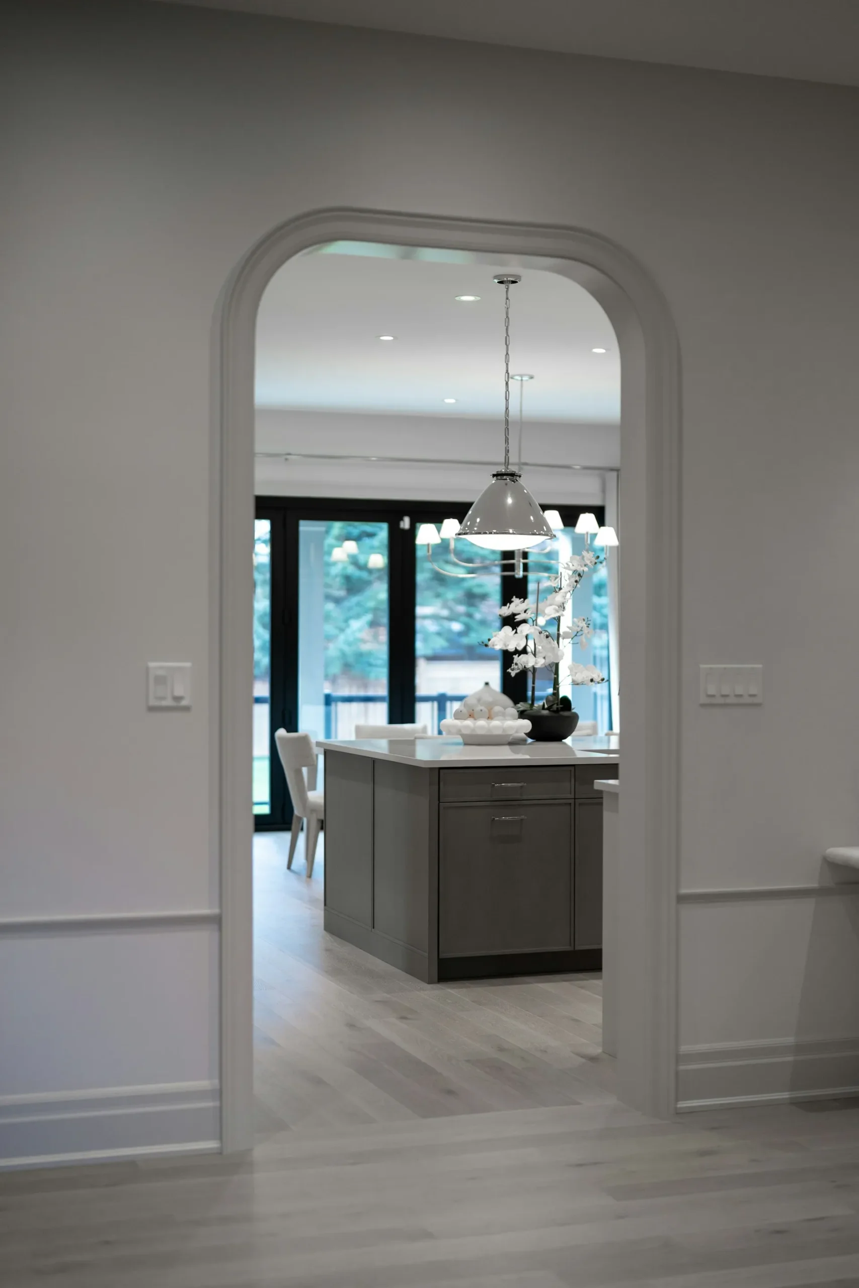 entryway to kitchen with arched doorway and wooden floor