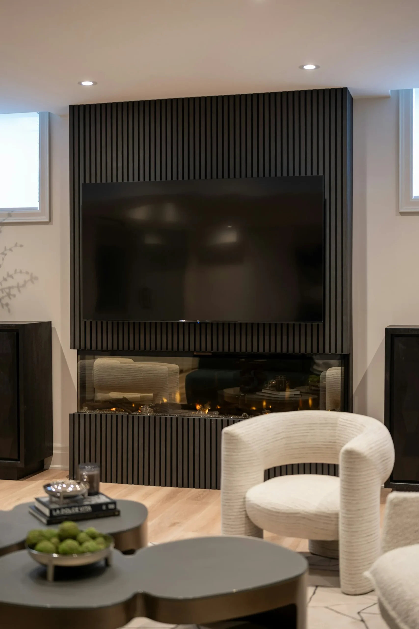 Modern living room with TV and dark fireplace wall.